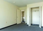 Thumbnail 9 of 12 - A hallway with white walls and a grey carpet.