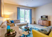 Thumbnail 7 of 28 - Model apartment living room family room with balcony and furnishings
