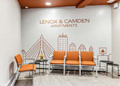 Thumbnail 13 of 17 - Lenox and Camden Apartments lobby with orange chairs and a cityscape mural.