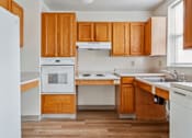 Thumbnail 2 of 14 - a kitchen with wooden cabinets and white appliances at Monterey Place, New Haven, CT, 06511