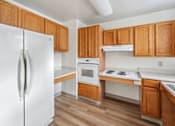Thumbnail 3 of 14 - Kitchen with white appliances and wooden cabinets at Monterey Place, Connecticut