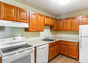 Thumbnail 1 of 15 - A kitchen with white appliances and wooden cabinets at Edmands House, Massachusetts, 01701