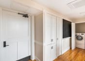 Thumbnail 9 of 16 - a laundry room with white cabinets and a washing machine at Beverly Village for Living & the Arts Apartments, Beverly