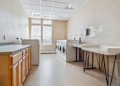Thumbnail 11 of 14 - a laundry room with sinks and washes and dryers in it  at Monterey Place, New Haven, CT, 06511