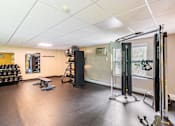 Thumbnail 9 of 14 - A gym with a weightlifting area and a bench. at Ship's Watch Apartments, Fall River, MA, 02720