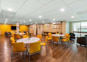 Thumbnail 11 of 14 - A room with a white table surrounded by yellow chairs. at Ship's Watch Apartments, Fall River, MA, 02720
