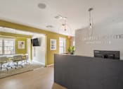 Thumbnail 4 of 19 - Leasing and Management Office  lobby with a reception desk and a table with chairs at Station Pointe Apartments, Mansfield, MA, 02048