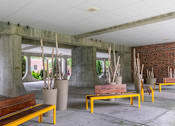 Thumbnail 12 of 17 - A concrete patio with benches and trees at Edmands House, Framingham, 01701