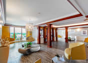Thumbnail 2 of 14 - A modern living room with a yellow chair and a large window. at Ship's Watch Apartments, Fall River, MA, 02720