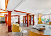 Thumbnail 1 of 14 - A large room with yellow chairs and a white table. at Ship's Watch Apartments, Fall River, MA, 02720