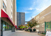Thumbnail 6 of 8 - A sunny day at the entrance of a building with a sign that says "Twin Village".