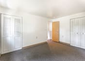 Thumbnail 11 of 12 - Bedroom with carpet and closet doors at Blue Ridge Estates Apartments, Virginia