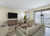 Thumbnail 6 of 16 - a living room with couches and a table and a television at Blue Hills Village, Canton, MA, 02021