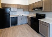 Thumbnail 1 of 12 - A kitchen with black appliances and wooden cabinets. at 35 Broadway Apartments, Menands, New York