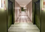 Thumbnail 6 of 12 - A long hallway with doors on either side and a light on the wall. at 35 Broadway Apartments, Menands, NY