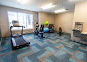 Thumbnail 7 of 12 - A room with a treadmill, exercise ball, and other workout equipment. at 35 Broadway Apartments, Menands, NY