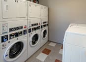 Thumbnail 12 of 12 - A row of washing machines are lined up in a laundry room. at 35 Broadway Apartments, Menands, 12204