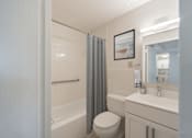 Thumbnail 3 of 15 - Modern bathroom with white vanity and tub at Baystate Place Apartments, Springfield, MA