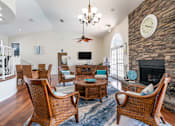 Thumbnail 11 of 14 - A living room with a fireplace and a large clock on the wall Fishermans Landing Apartments in Ormond Beach, FL.