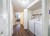 Thumbnail 5 of 14 - A white laundry room with a washer and dryer Fishermans Landing Apartments in Ormond Beach, FL.