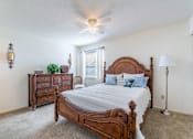 Thumbnail 3 of 14 - A bedroom with a large bed and a dresser Fishermans Landing Apartments in Ormond Beach, FL.