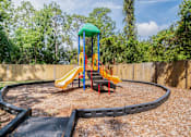 Thumbnail 12 of 14 - A playground with a yellow slide and a green roof Fishermans Landing Apartments in Ormond Beach, FL.