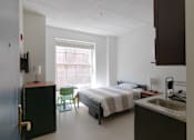Thumbnail 10 of 14 - a bedroom with a bed and a sink and a chair  at 140 Clarendon, Boston, MA, 02116