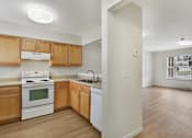 Thumbnail 11 of 17 - Kitchen Layout With Modern Appliances, Light Countertops, and Wooden Cabinetry at Creekwood Apartments, Watertown, 13601
