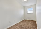 Thumbnail 17 of 17 - Bedroom Layout, Large Window, Carpeted Flooring at Creekwood Apartments, Watertown, NY.