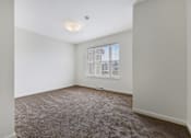 Thumbnail 14 of 17 - Bedroom Layout, Large Window, Carpeted Flooring at Creekwood Apartments, Watertown, NY.