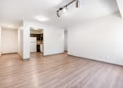 Thumbnail 20 of 21 - A large empty room with wooden floors and white walls.