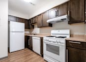 Thumbnail 17 of 21 - A kitchen with white appliances and brown cabinets.