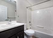 Thumbnail 21 of 21 - A white toilet sits next to a white bathtub in a bathroom.