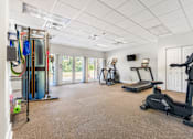 Thumbnail 10 of 21 - A spacious room with exercise equipment and a television.