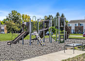 Thumbnail 7 of 21 - A playground with a green slide and a brown slide.