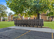 Thumbnail 8 of 21 - A large black sign with many small squares is in the foreground of a parking lot.