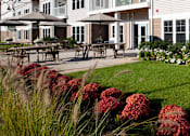 Thumbnail 13 of 15 - Exterior View and Outdoor Patio Seating Area at Ocean Shores Apartments in Marshfield, MA