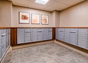 Thumbnail 7 of 14 - A row of grey lockers are lined up against a wall with two framed pictures hanging above them at Pok Oi Residences, Boston, MA, Massachusetts, 2111