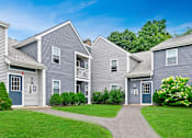 Thumbnail 15 of 16 - a row of houses with blue siding and green grass at Blue Hills Village, Canton, Massachusetts