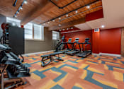 Thumbnail 10 of 15 - A gym with a wooden ceiling and a treadmill at The Cordovan at Haverhill Station, Haverhill, MA