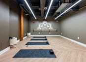 Thumbnail 12 of 15 - A yoga studio with wooden floors and mats at The Cordovan at Haverhill Station, Haverhill, MA
