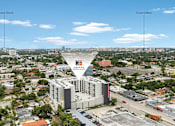 Thumbnail 11 of 15 - A large building with a sign that says "ENCLAVE" is in the middle of a city.