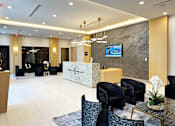 Thumbnail 4 of 36 - a modern hotel lobby with a reception desk and chairs  at Douglas Enclave, Miami