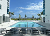 Thumbnail 6 of 36 - an outdoor pool with lounge chairs and a view of the Miami skyline  at Douglas Enclave, Miami, FL, 33125