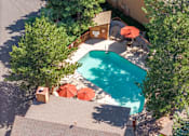 Thumbnail 28 of 42 - An aerial view of a pool surrounded by trees and chairs.