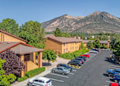 Thumbnail 6 of 42 - A parking lot with cars and a mountain in the background.
