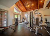 Thumbnail 39 of 42 - A home gym with a variety of equipment including a treadmill, weights, and a bench press.