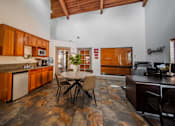 Thumbnail 40 of 42 - A kitchen with wooden cabinets and a stone floor.