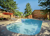 Thumbnail 29 of 42 - A swimming pool surrounded by trees and chairs.