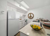 Thumbnail 11 of 18 - A kitchen with a bowl of fruit on the counter.